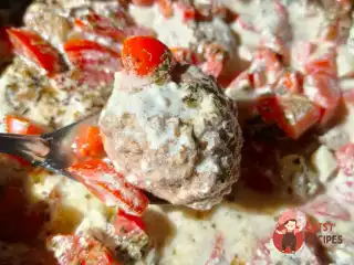 Тефтелі з яловичо-курячого фаршу тушковані з помідорами та часником у сметанному соусі