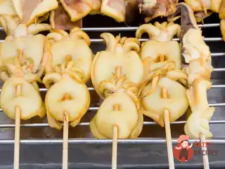 Кальмари на грилі з лимонно-каперсовим соусом та червоним перцем.