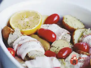 Тріска, запечена в духовці з картоплею, помідорами та беконом