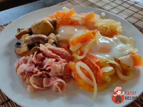 Яєчня з беконом, цибулею, помідором та грибами