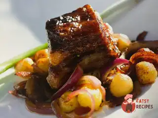 Глазурована свинина зі смаженими яблуками, картоплею та червоною цибулею