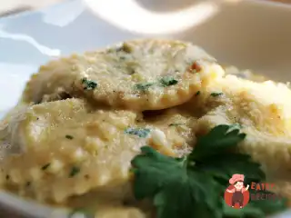 Равіолі з гребінцями та креветками у вершковому соусі.