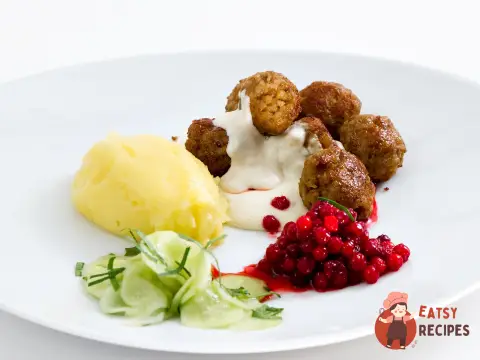 Тефтелі з брусничним соусом, маринованим огірком та коричневим соусом