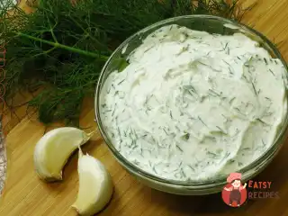 Часниковий соус з жовтком, лимонним соком, гірчицею, оливковою олією, зеленню та перцем.