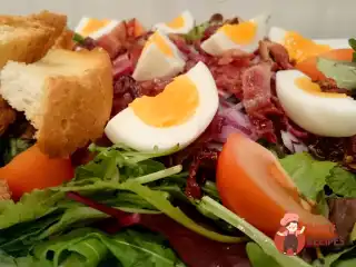 Салат з авокадо, яєць, бекону та печених помідорів.