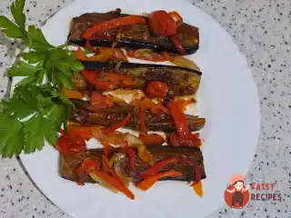 Баклажани з овочами та соєвим соусом на сковороді.