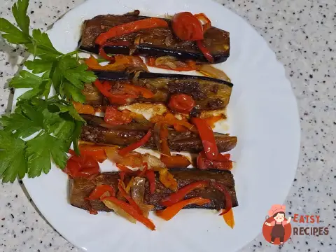 Баклажани з овочами та соєвим соусом на сковороді.