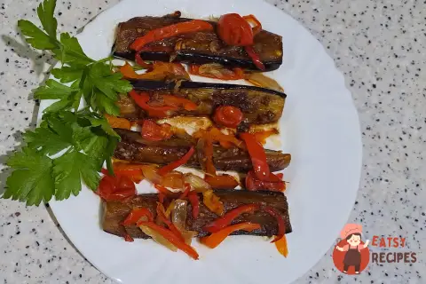 Баклажани з овочами та соєвим соусом на сковороді.