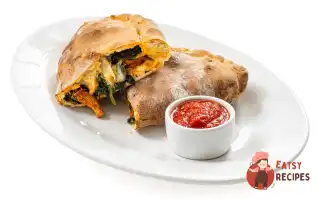 Закрита піца кальцоне з грибами та шпинатом