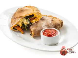 Закрита піца кальцоне з грибами та шпинатом