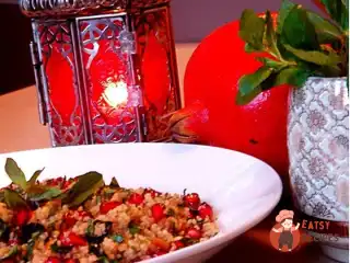 Кускус із зернами гранату, кедровими горішками, родзинками та йогуртом.