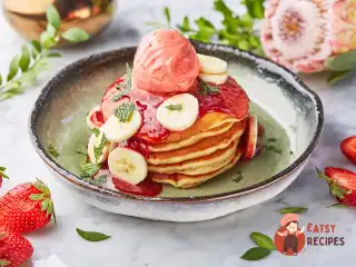 Панкейки з бананом, полуничним варенням та морозивом