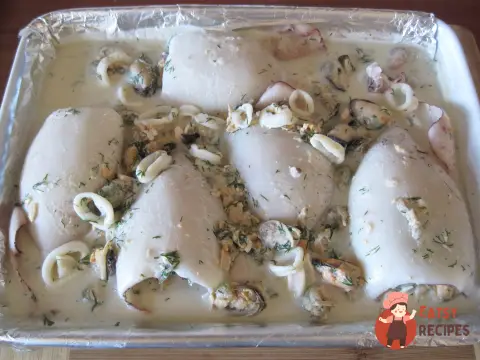 Фаршировані морепродуктами кальмари, запечені у вершковому соусі
