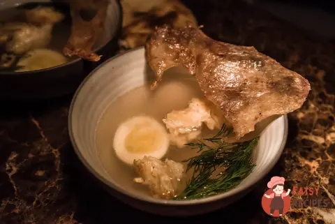 Курячий бульйон з яйцем і чіпсом з курячої шкіри