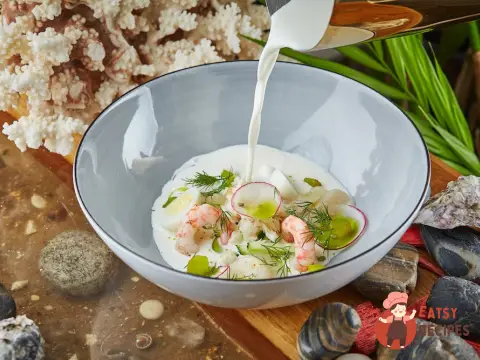 Біла окрошка з морепродуктами, копченою тріскою та овочами.
