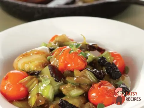 Цибуля, тушкована з чорносливом і помідорами чері.