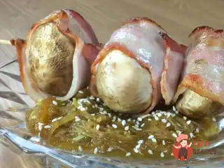 Печериці, запечені в беконі на подушці з кабачків