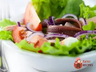 Салат з помідорів, червоної цибулі та анчоусів.