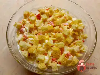 Пікантний салат з крабовими паличками, сиром та сухариками.