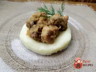 Свинина тушкована з цибулею на картопляному пюре