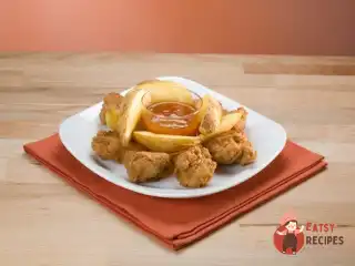 Золотисті курячі шматочки у сухарях з абрикосово-гірчичним соусом.