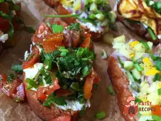 Брускетта з томатом, руколою, омлетом та горіховим соусом.