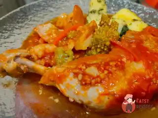 Курячі стегна тушковані в томаті з овочами