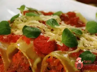 Каннеллоні з м'ясною начинкою, запечені в томатному соусі.