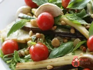 Теплий салат із запеченими овочами, зеленню та кедровими горіхами