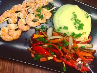 Креветки на шпажках з пюре з васабі та смаженими овочами.