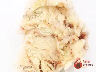 Морозиво зі шматочками булочки синнабон і коричневим соусом.