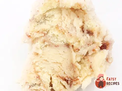 Морозиво зі шматочками булочки синнабон і коричневим соусом.