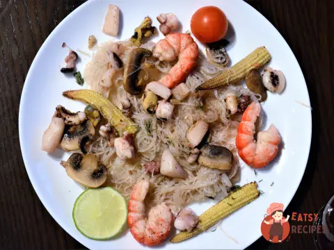 Вок із рисової локшини з морепродуктами, печерицями та кукурудзою.