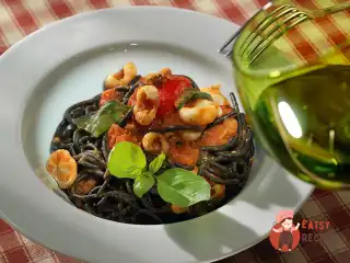 Чорний спагетті з соусом з помідорів і каракатиць.