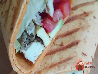 Тортілья з куркою, помідорами та авокадо на грилі.