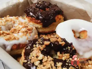 Сирні пончики в білий і шоколадний глазурі.