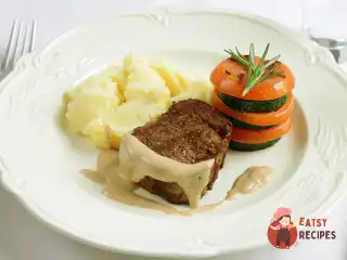 Стейк з перцевим соусом, картопляним пюре та мільфеєм з цукіні та томатів
