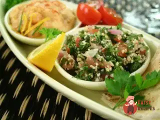Салат із кускусу з нутом, червоними перцями та заправкою з куміну.