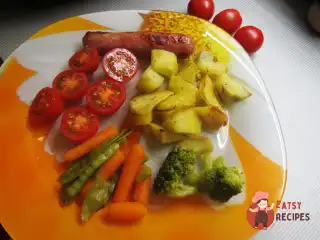 Ковбаски гриль з картопляними часточками, томатами та брокколі